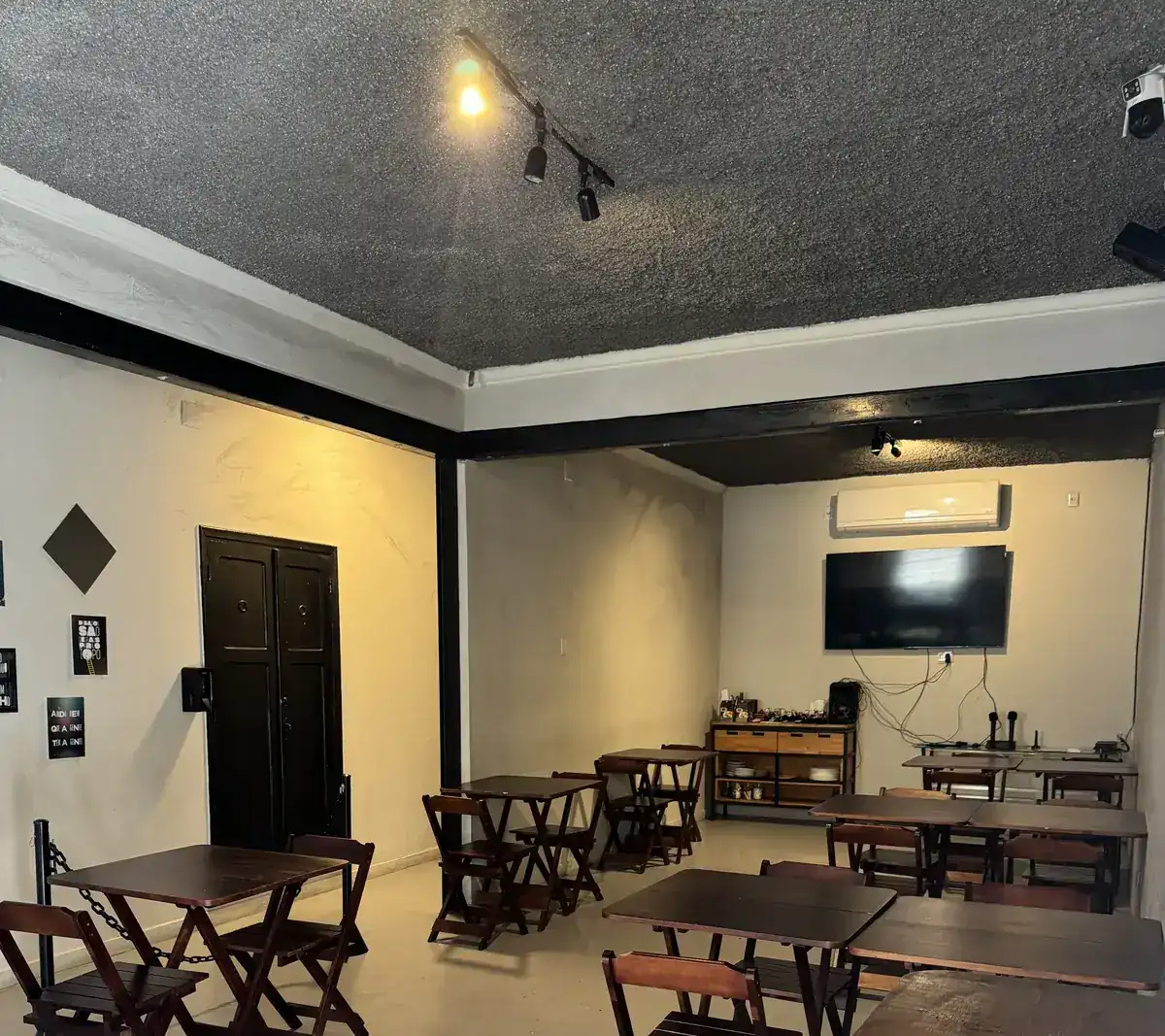 Ambiente do Zora Bar preparado para aniversário, com mesas de madeira