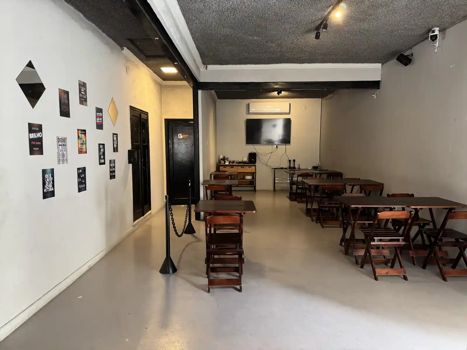 Salão de festas privativo do Zora Bar em Santos, montado com mesas de madeira para um evento