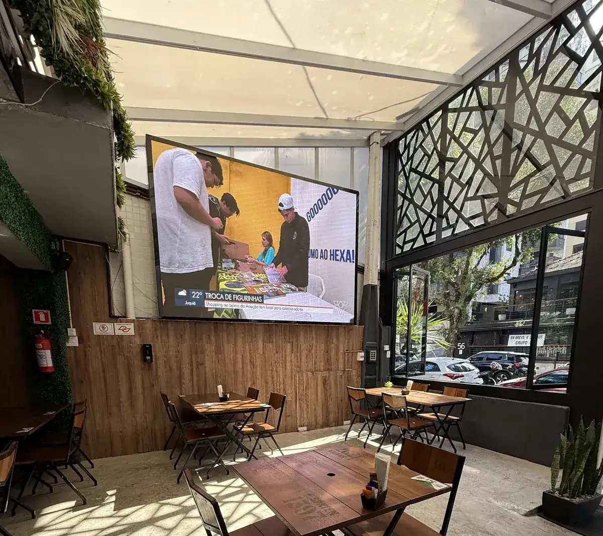 Telão do Zora Bar transmitindo jogo de futebol para o salão principal