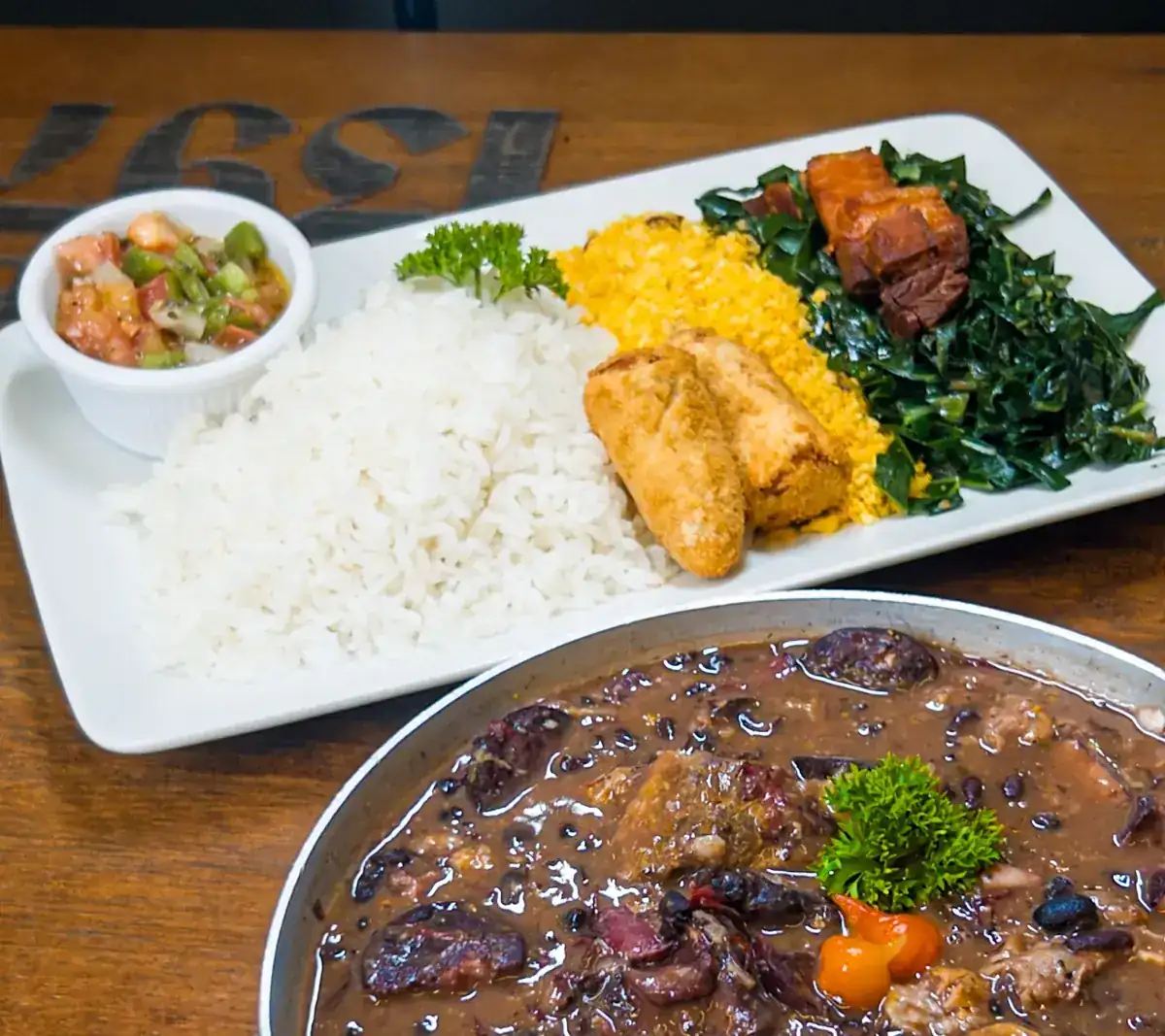 Feijoada completa servida na panela com acompanhamentos